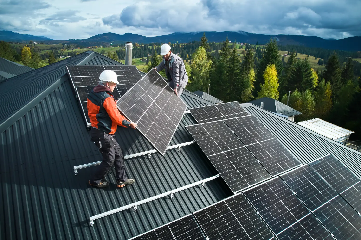 Arbeiter montieren Solarmodulanlage auf einem Hausdach.